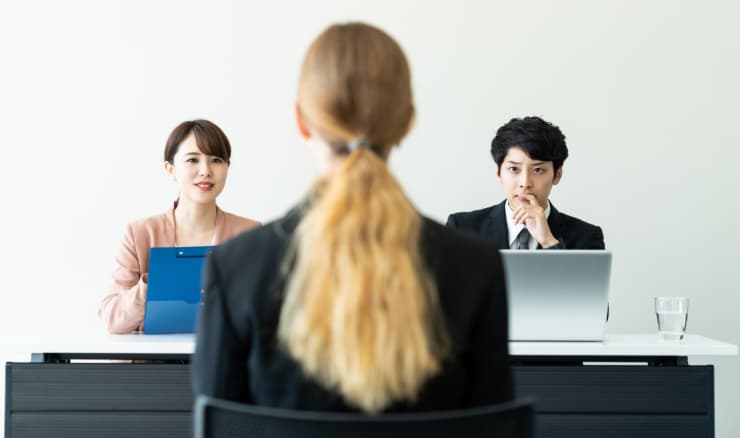 面接を受ける外国人女性と質問する面接官たち