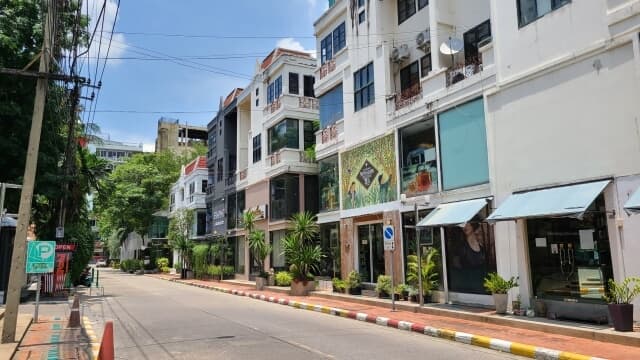 日中のタイの通りにある建物と植物