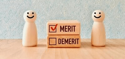 「メリット」にチェックが入った積み木と、「デメリット」にチェックが入っていない積み木を、木製の人形が挟んでいる画像です。